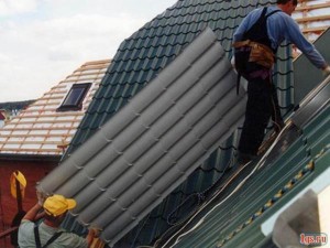 Строители тянут лист на крышу